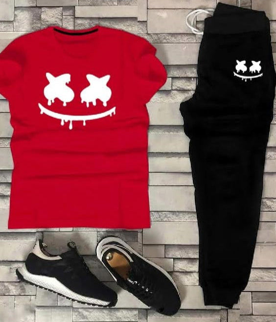 Red t-shirt, black pants, and black sneakers with a white logo on a stone surface