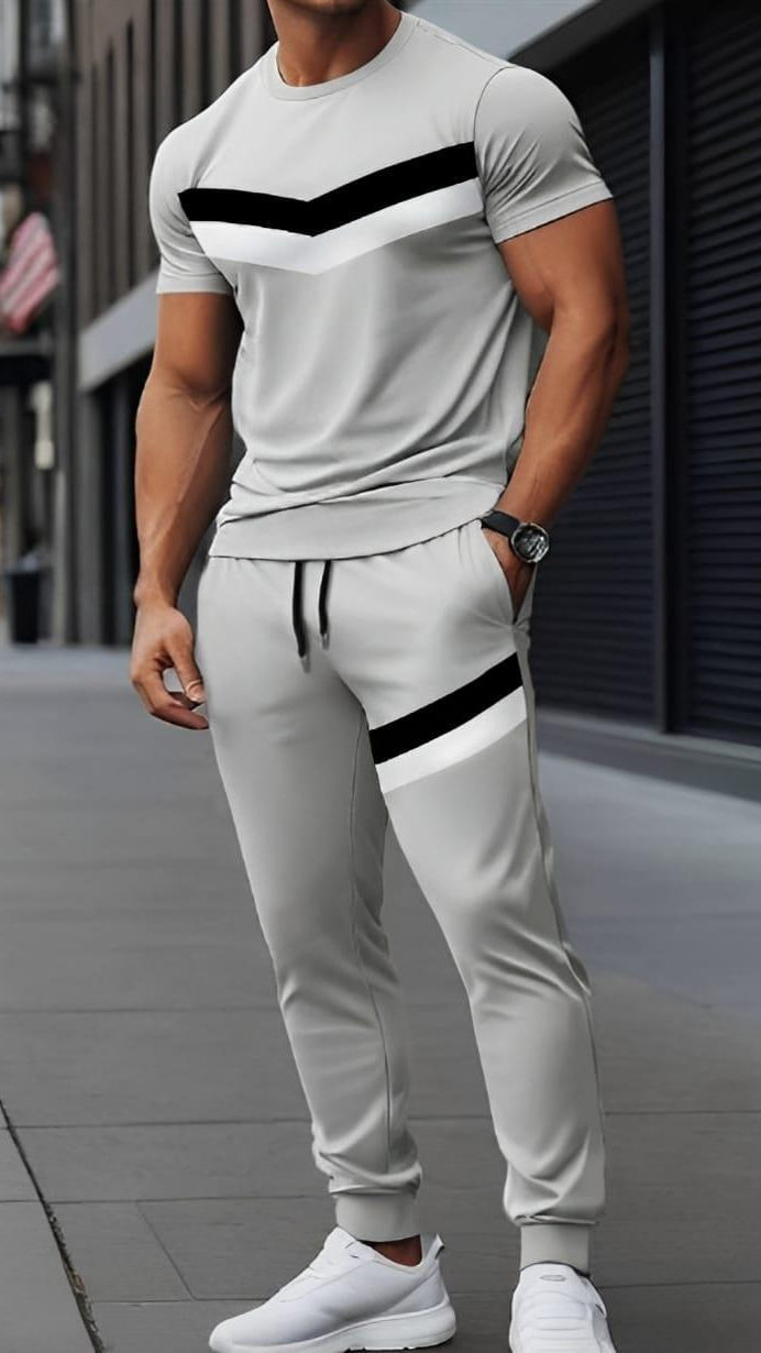 Man wearing a gray and white outfit with black stripes on a city street.