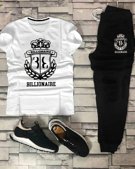 White t-shirt, black pants, and black sneakers with 'Billionaire' branding on a stone wall background.