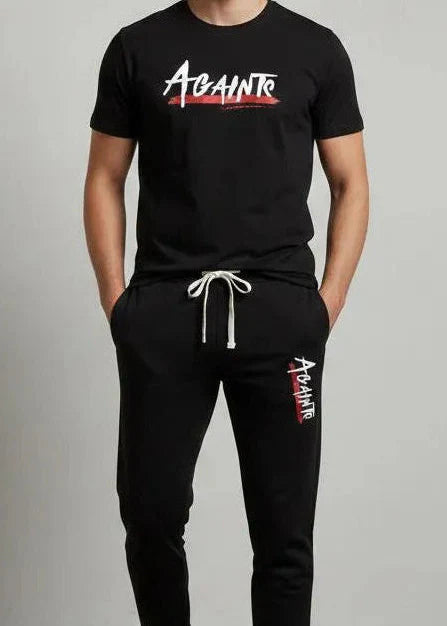 Man wearing a black 'Against' t-shirt and pants on a gray background