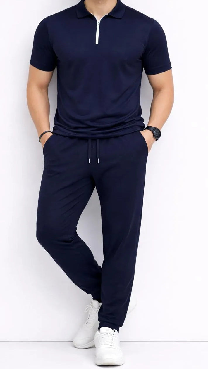 Man wearing a navy blue outfit with white sneakers on a white background