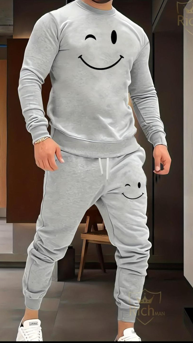 Person wearing a gray tracksuit with smiley face design in an indoor setting